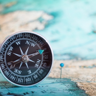 A compass lies on a world map. Let us steer your financial accounting and payroll accounting for your company.